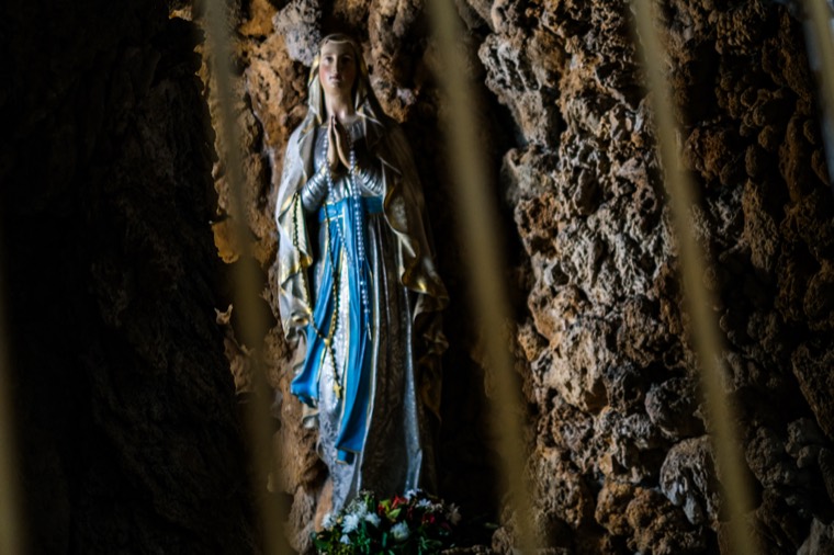 Madonna statue through bars