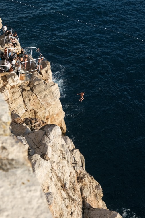cliff diver mid-air jump