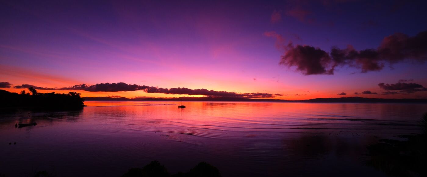 A purple and orange sunset over still water in Fiji