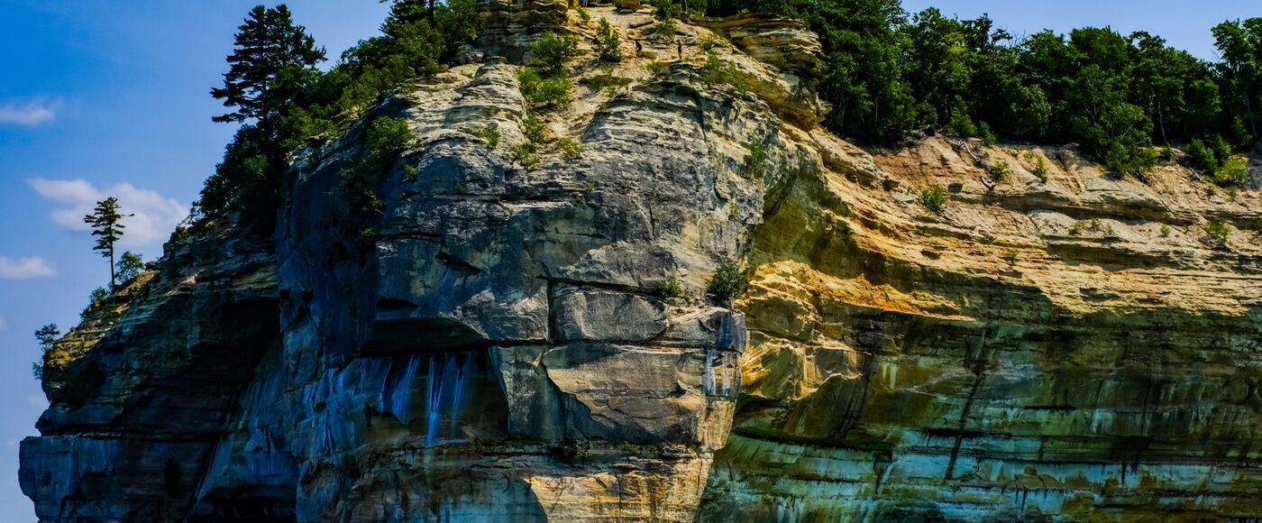 Layered sandstone cliffs above the clear water of Lake Superior at Pictured Rocks, Michigan